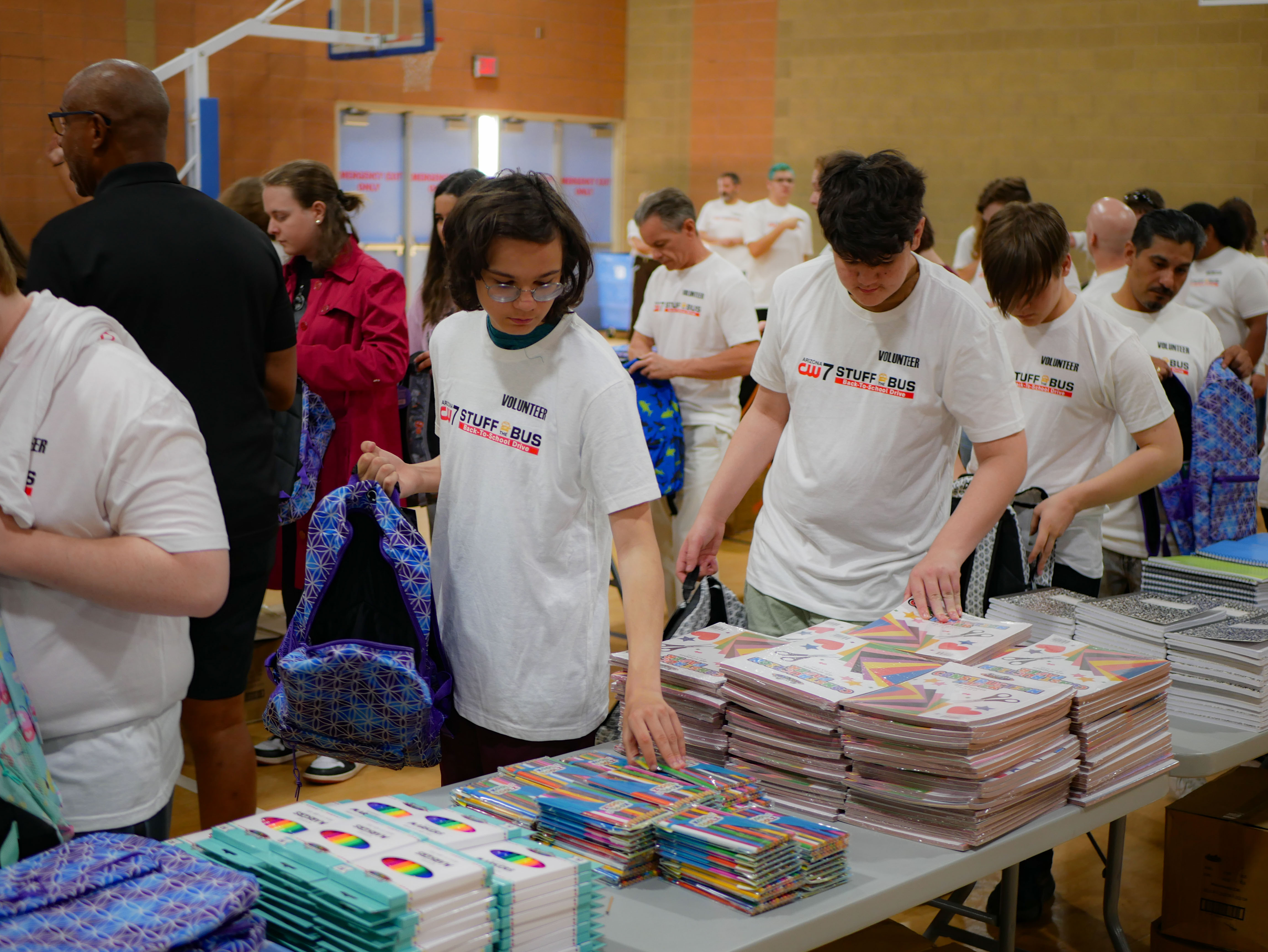 Students stuff backpacks with school supplies and classroom essentials during the Stuff the Bus event